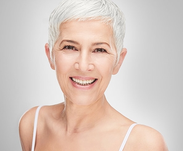 Smiling older woman with short gray hair.