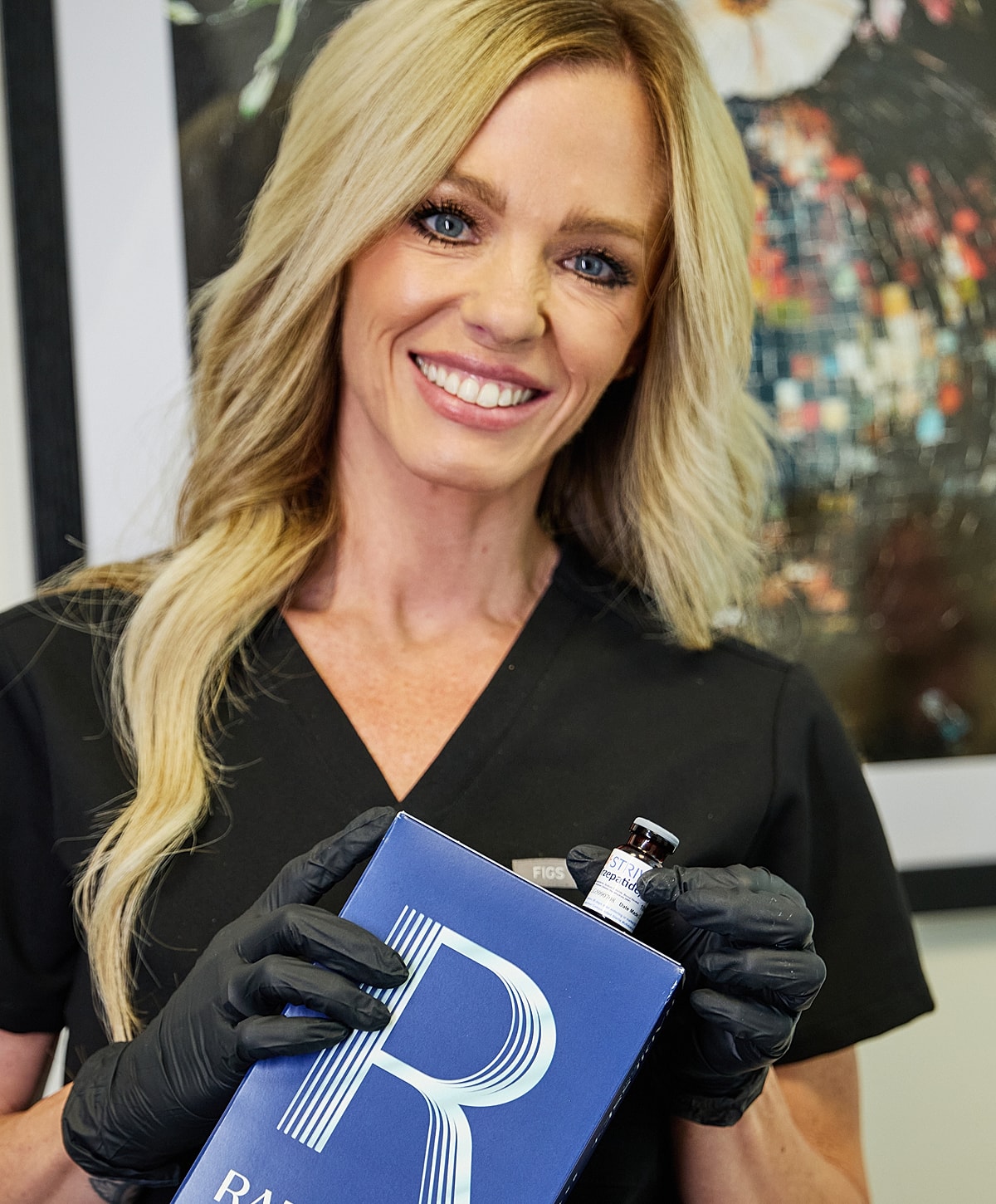 Smiling professional holding skincare product and vial.