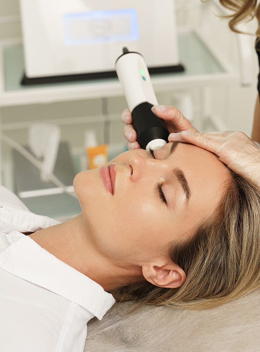 Woman receiving facial treatment in spa setting.