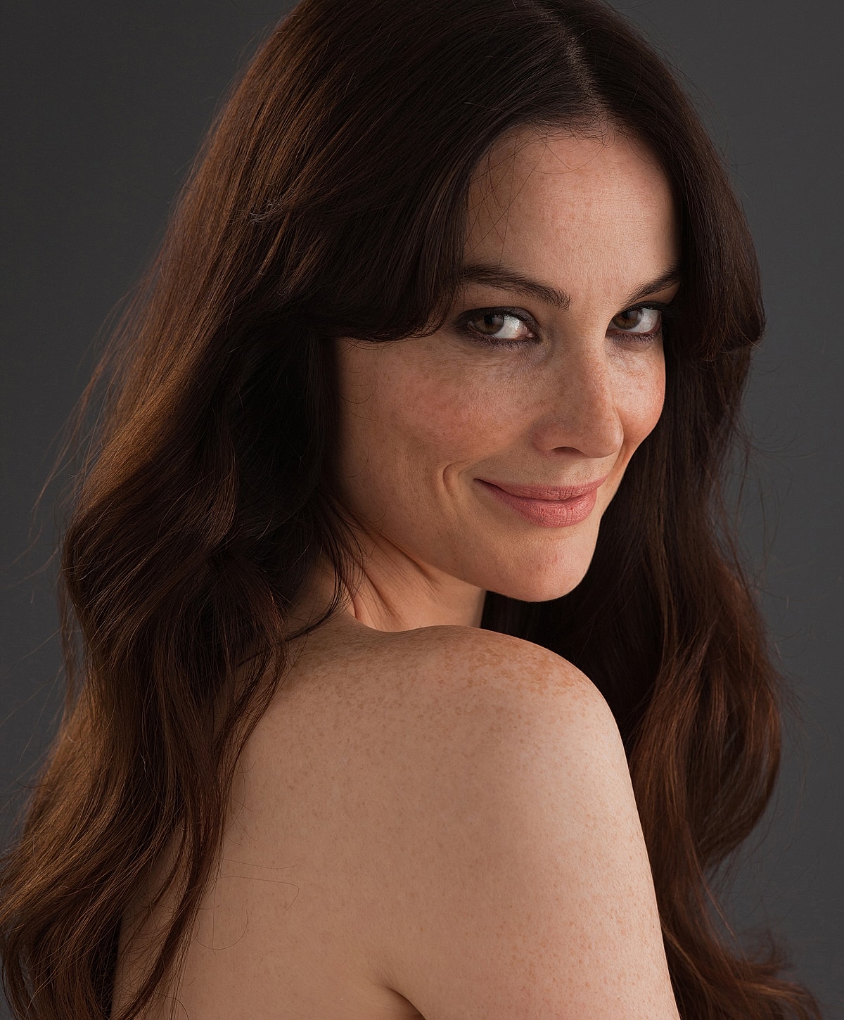 Smiling woman with long, wavy hair.