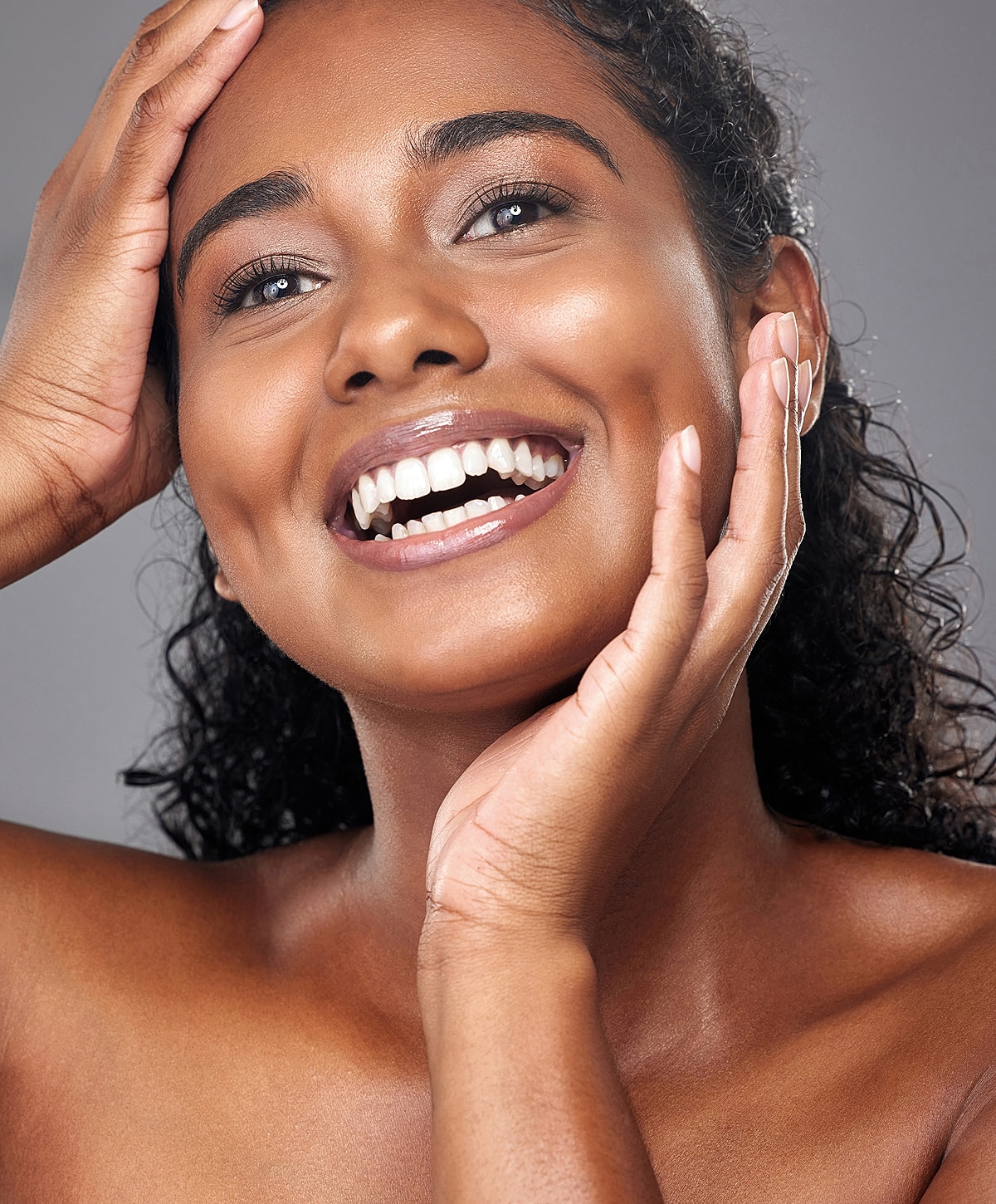Smiling woman with curly hair, showcasing radiant beauty.