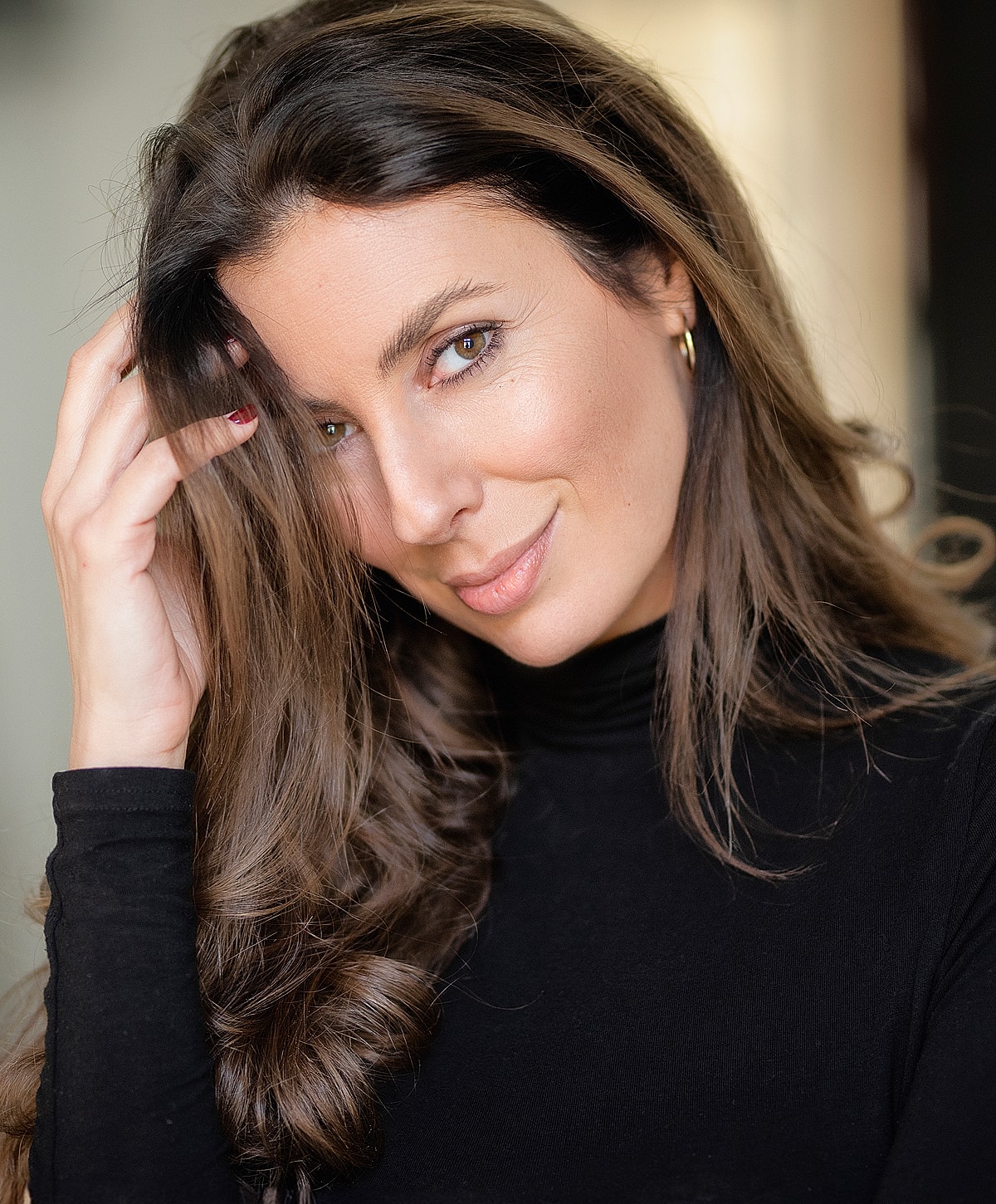 Woman smiling with long, wavy brown hair.