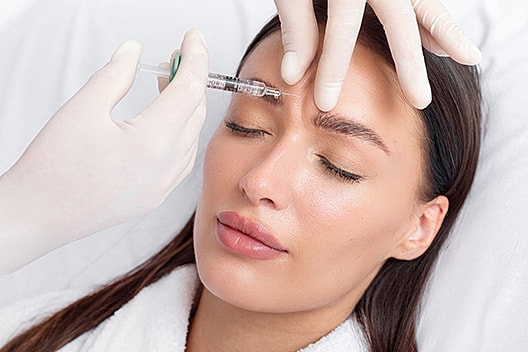 Botox injection procedure on a woman's forehead.
