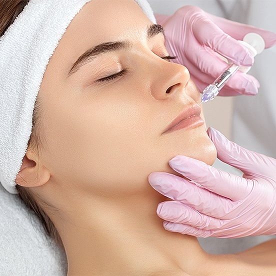 Beauty treatment session with woman receiving injection.