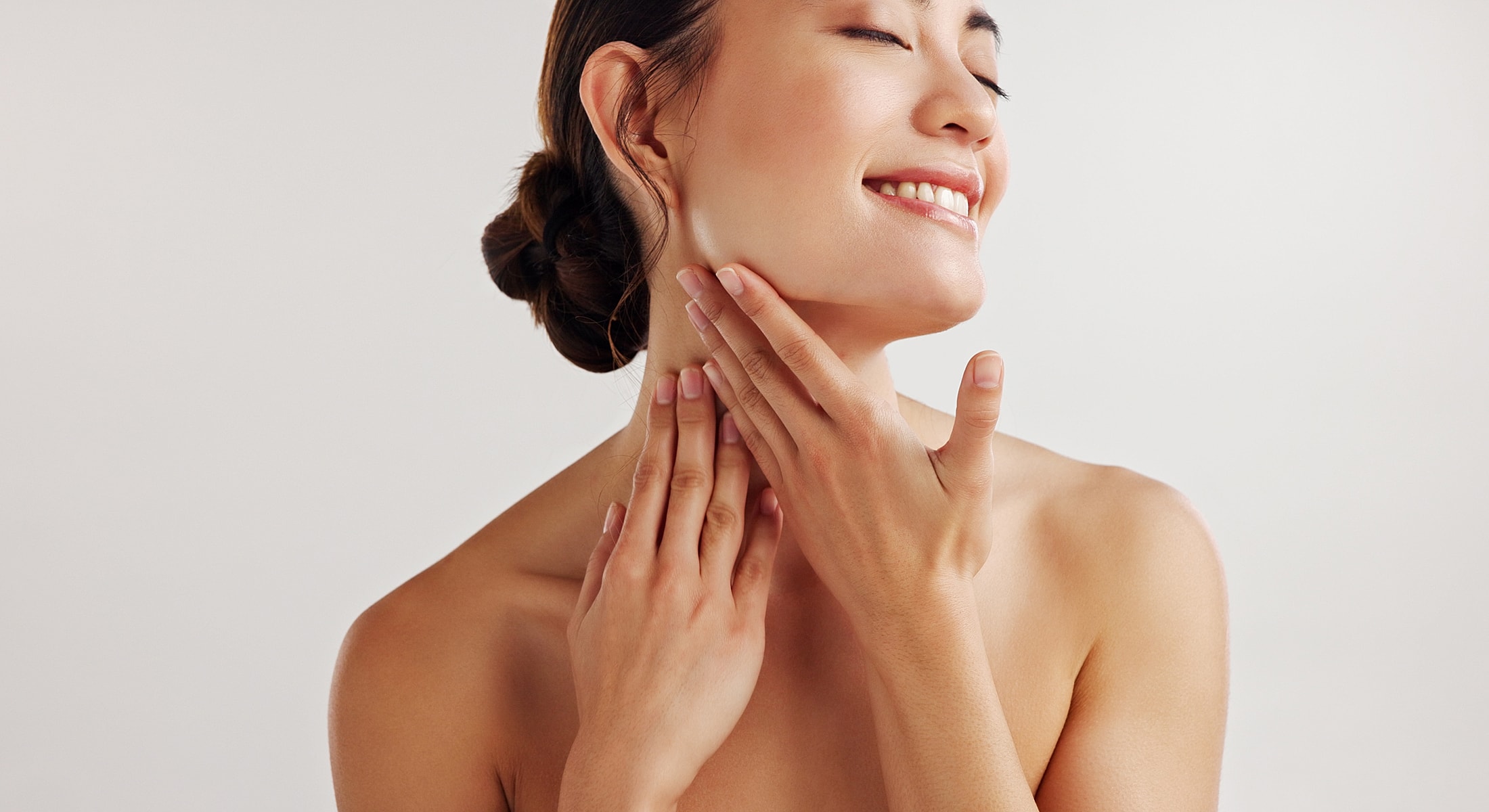 Woman gently touching her face and neck.