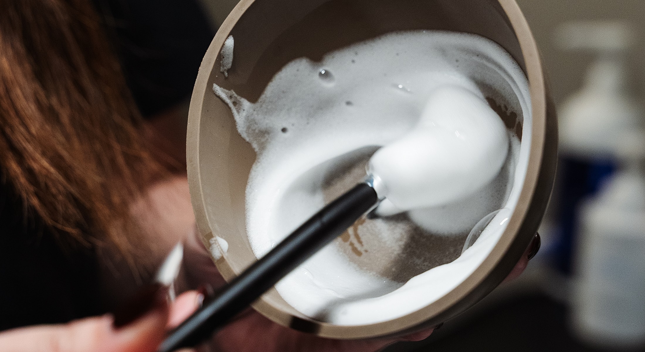 Mixing foam in a bowl with a brush.