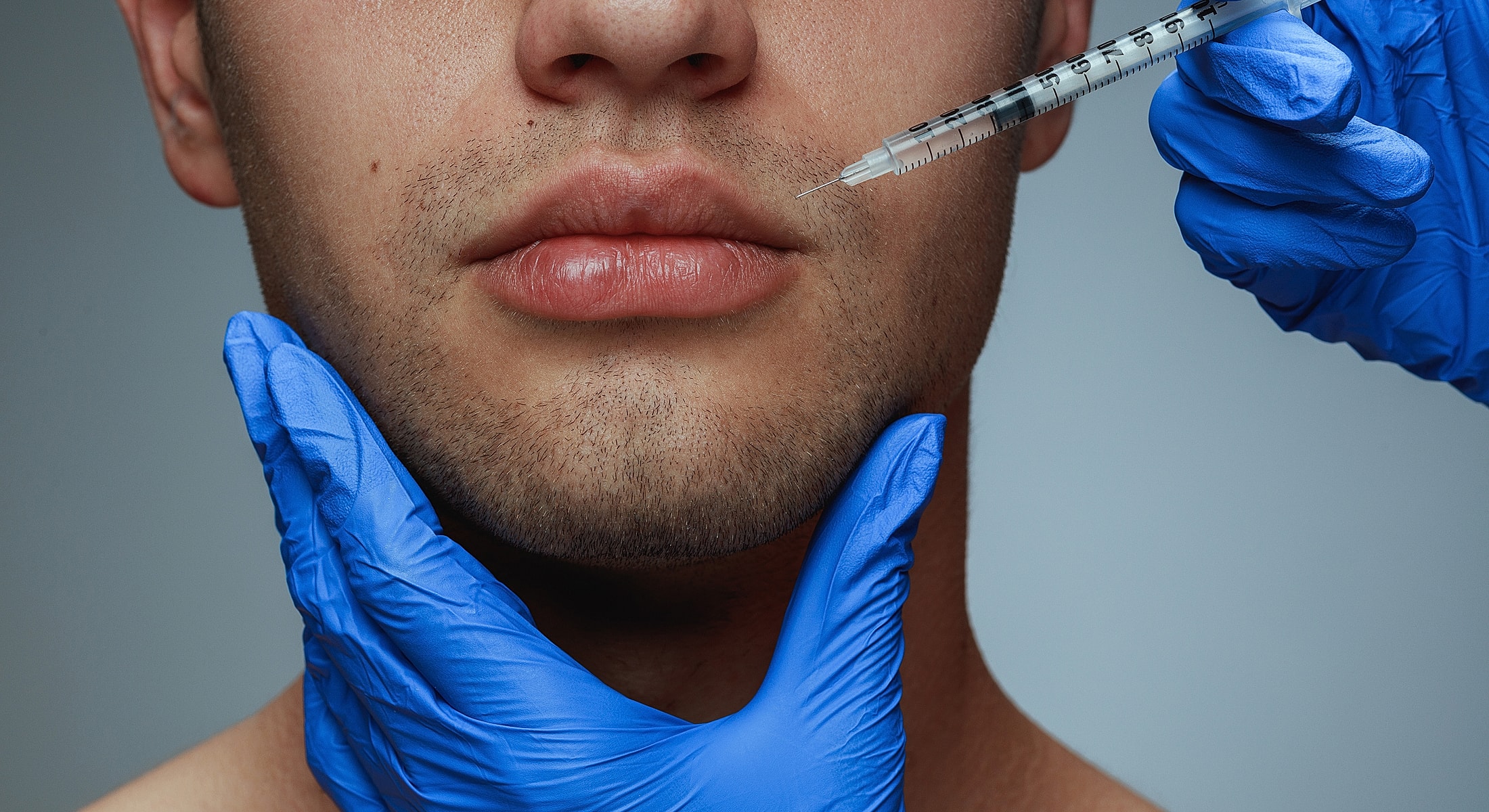 Cosmetic injection procedure on a man's lips.