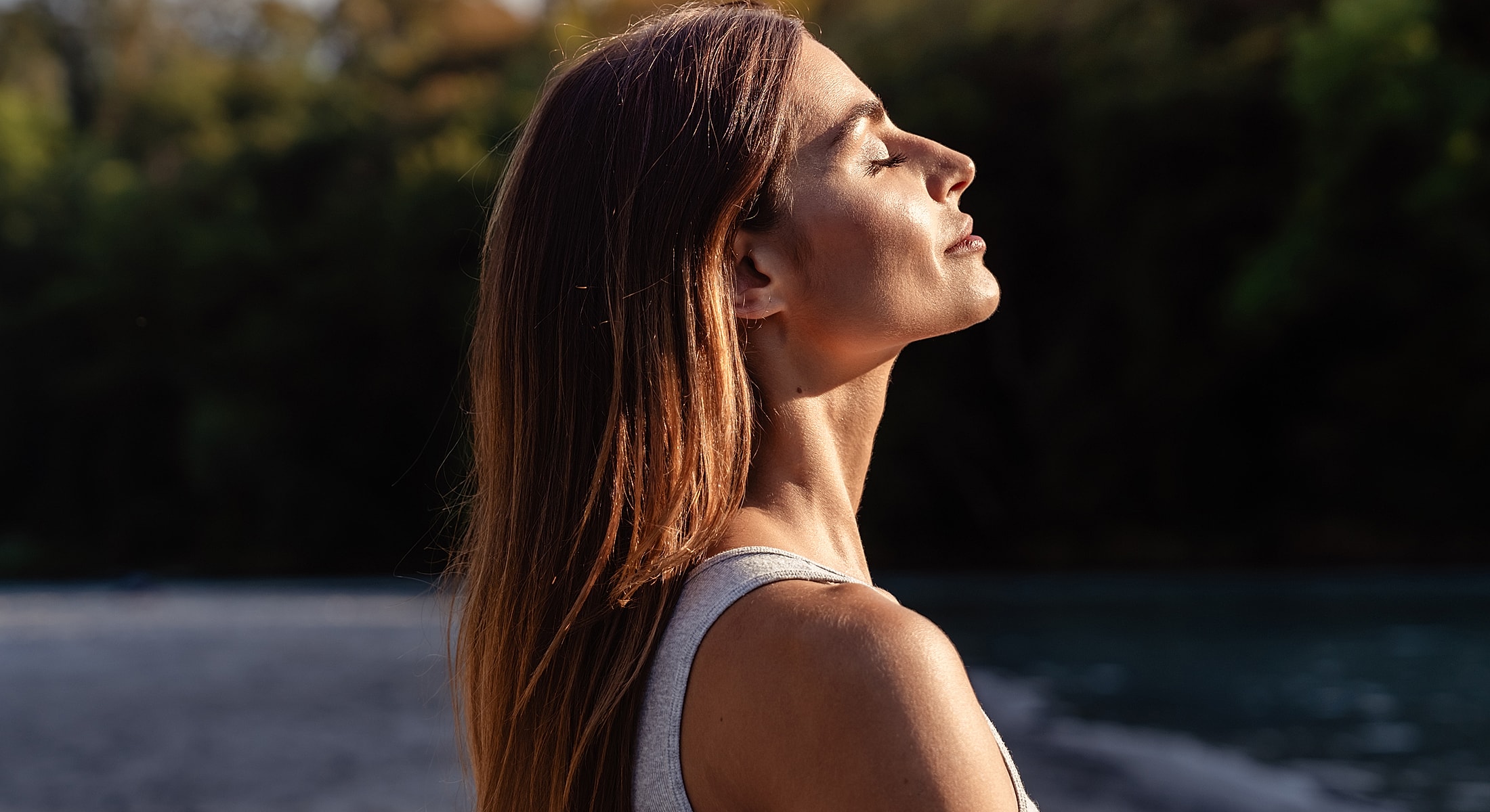 Woman with eyes closed enjoying nature's calm.